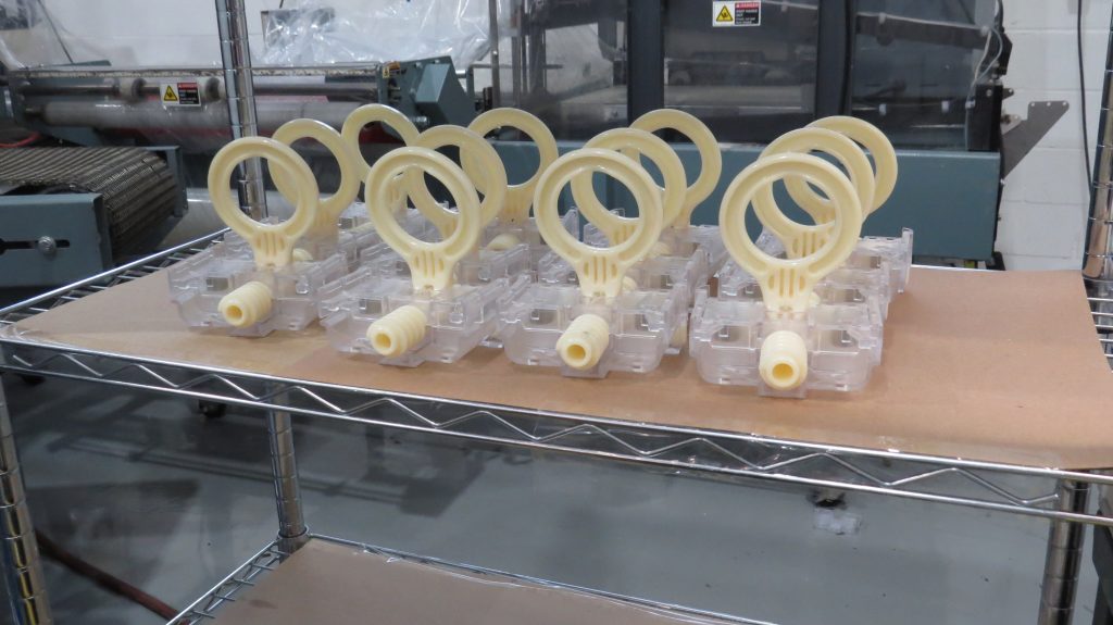 Injection molded plastic components on a production rack at Baytech during a molding program transfer.